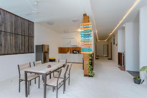 a kitchen and dining room with a table and chairs at Violet Inn Hotel in Dharavandhoo
