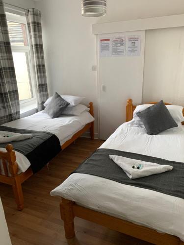 a bedroom with two beds and a window at Alderley Hotel Blackpool in Blackpool