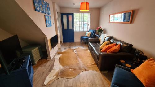 a living room with a black leather couch and a rug at The Kingfisher, by Spires Accommodation a great location for visiting the NEC and Drayton Manor in Kingsbury