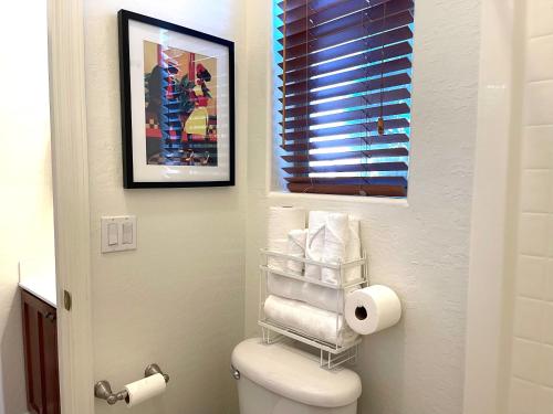 a bathroom with a toilet and a picture on the wall at Casita Alkie in Litchfield Park