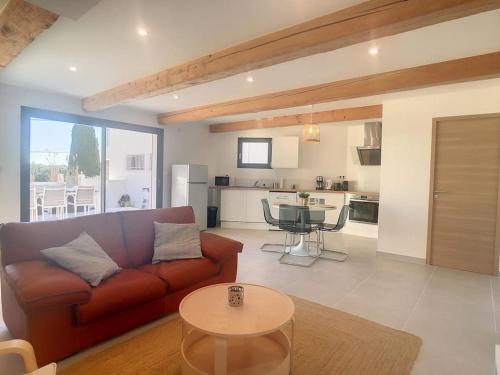 a living room with a couch and a table at La Parenthèse maison T3 au calme avec parking gratuit in Les-Pennes-Mirabeau