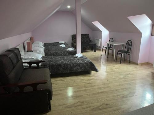 a bedroom with two beds and a table and chairs at Hotel New Star in Akhaltsikhe