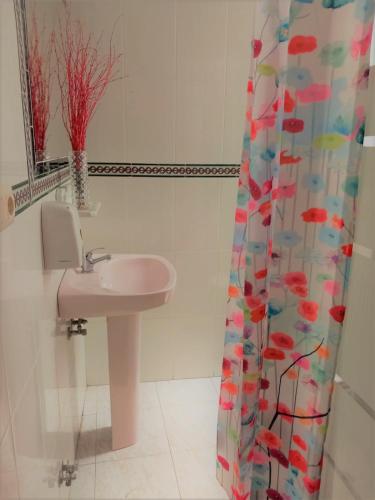 a bathroom with a sink and a shower curtain at SevillaDream in Seville