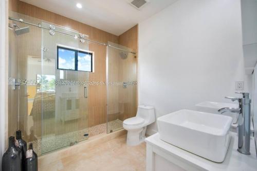 a bathroom with a shower and a toilet and a sink at Fendi Mansion with Pool Central Miami Piano and Pool table in Miami