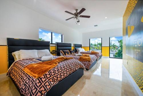 a bedroom with two beds and a ceiling fan at Fendi Mansion with Pool Central Miami Piano and Pool table in Miami