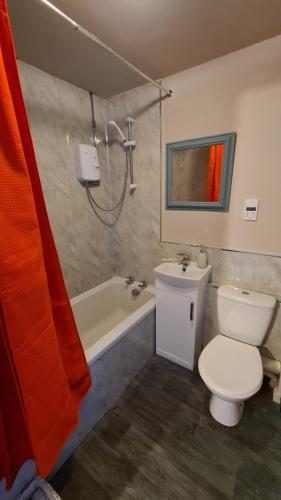 a bathroom with a toilet and a tub and a sink at The Kingfisher, by Spires Accommodation a great location for visiting the NEC and Drayton Manor in Kingsbury
