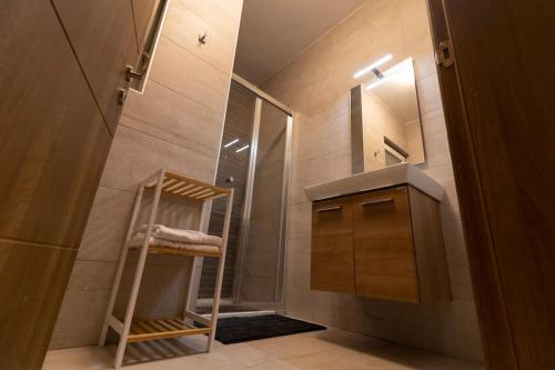 uma casa de banho com um espelho, um lavatório e um chuveiro em Lovely Modern 1 Bedroom Apartment in San Gwann em San Ġwann