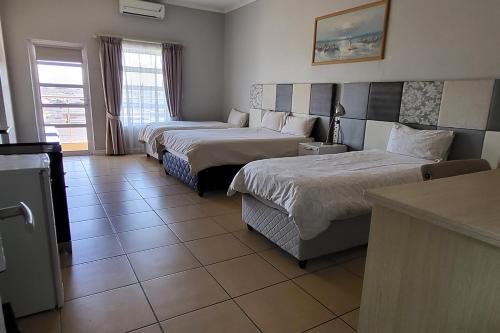 a hotel room with two beds and a kitchen at SHALIMAR GARDENS HOTEL in Cape Town