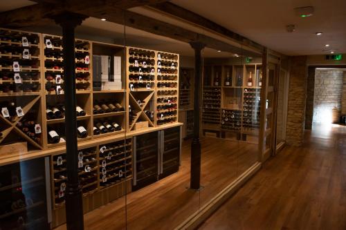 a wine cellar with a wall of wine bottles at The Haycock Manor Hotel in Wansford