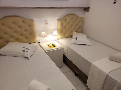 two beds sitting next to each other in a room at Pousada Dragao Do Mar in Fortaleza