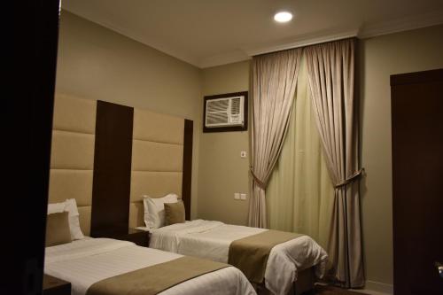 a hotel room with two beds and a window at Lamasat Abha Hotel 2 in Abha