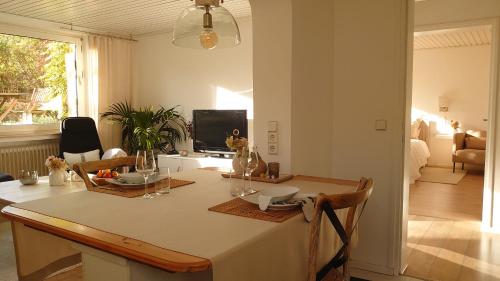 a dining room with a table and a television at Ferien am See in Möhnesee