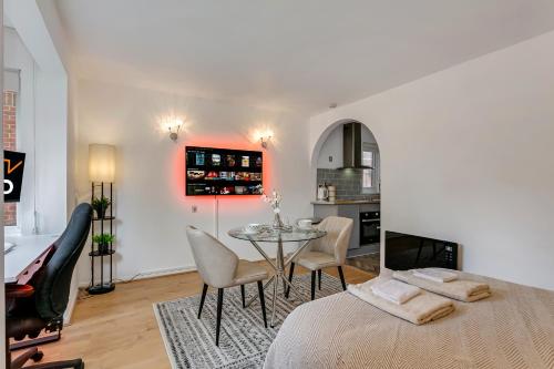1 dormitorio con 1 cama, mesa y sillas en Aryas Apartments London en Edgware