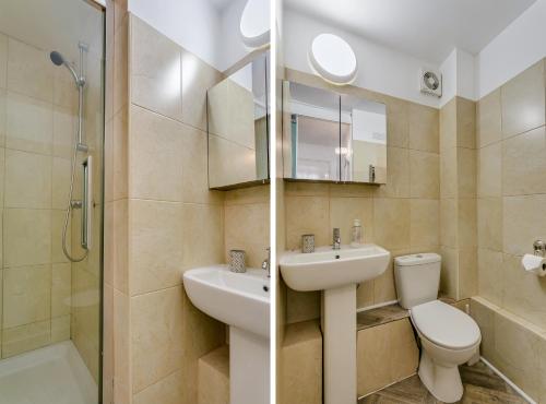 a bathroom with a sink and a toilet and a shower at Aryas Apartments London in Edgware