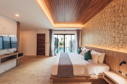 奧南海灘的住宿－Poonsiri Varich Pool Villa Aonang，一间卧室配有一张大床和电视