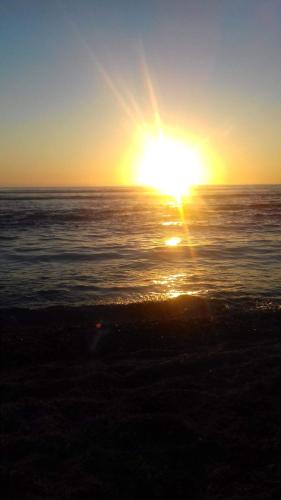 a sunset over the ocean with the sun in the sky at Bungalow charmant à Les Trois Bassins avec vue sur mer in Grande Ravine