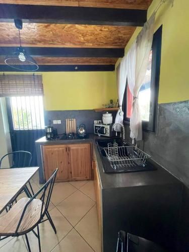 a kitchen with a stove top oven next to a table at Bungalow charmant à Les Trois Bassins avec vue sur mer in Grande Ravine