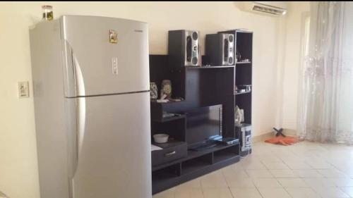 a kitchen with a white refrigerator and black shelves at شرم الشيخ قرية الليمار in Ash Shaţţ