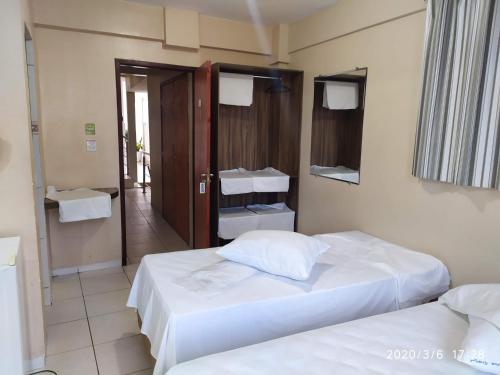 a hotel room with two beds and a hallway at Pousada Dragao Do Mar in Fortaleza