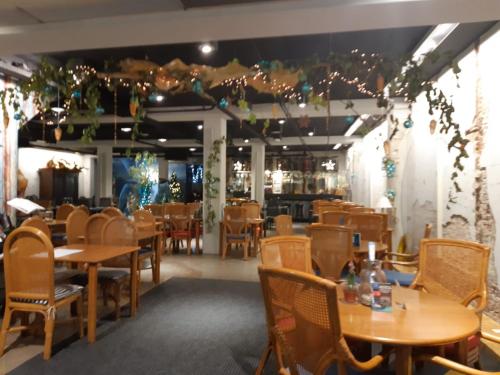 a restaurant with wooden tables and chairs and lights at Residentie d'Ouwe Kercke in Terneuzen