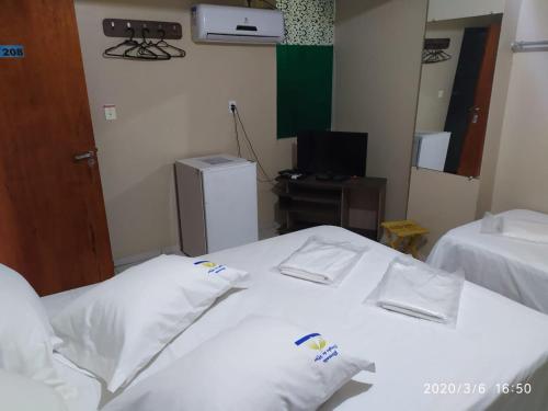 a hotel room with two beds and a television at Pousada Dragao Do Mar in Fortaleza