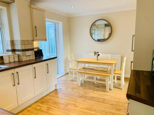 a kitchen and dining room with a table and a mirror at Homely Detached 3 bedroom house near Sheffield in Rotherham