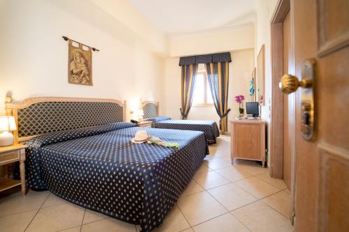 a hotel room with two beds and a window at Hotel Villa Romana in Porto Empedocle