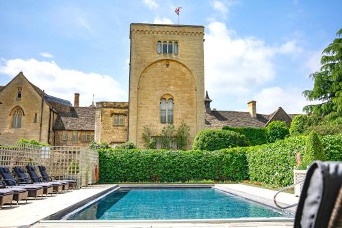 a house with a swimming pool in front of a building at Ellenborough Park in Cheltenham