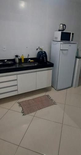 a kitchen with a sink and a refrigerator at Aconchego Familiar Veredas in Viçosa