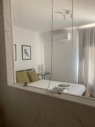 um espelho que reflecte uma cama num quarto branco em Herdade Da Maridona - Agroturismo em Estremoz