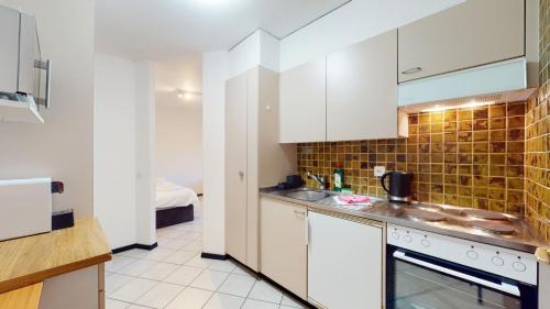 谢尔Spacious studio in a nice area in Sierre的带白色橱柜和水槽的厨房