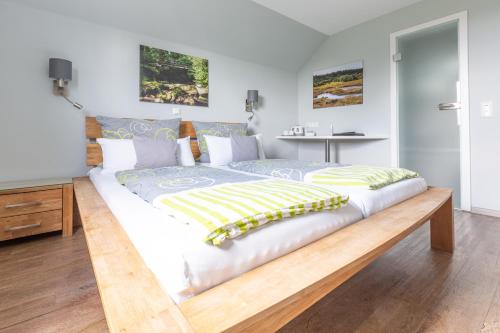 ein Schlafzimmer mit einem großen Bett mit einem Holzrahmen in der Unterkunft Venngasthof Zur Buche in Monschau