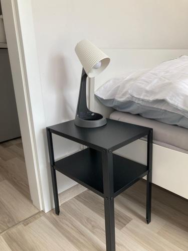 a lamp on a black table next to a bed at Cisy Resort-bon turystyczny,,ogrodzony teren na wyłączność,150 m od jeziora in Makosieje
