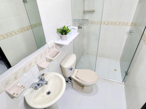a bathroom with a toilet and a sink and a shower at Apartamento frente a la playa 5B - By Bedviajes in Santa Marta