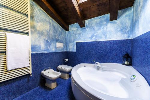 baño azul con bañera blanca y aseo en Palazzo Regina, en Verona