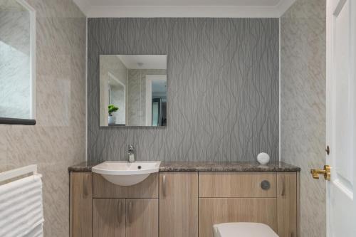 a bathroom with a sink and a mirror at Golwg Y Môr - Sea View Cottage with Hot Tub in Saundersfoot