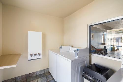 a laundry room with a refrigerator and a mirror at Knights Inn Sierra Vista / East Fry in Sierra Vista