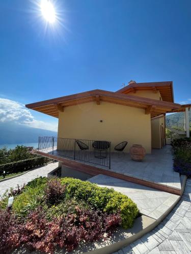 a house with a balcony with a table and chairs at La Terrazza sul Lago, Tignale in Tignale