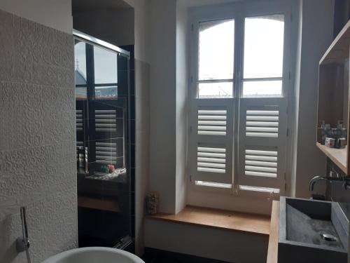łazienka z oknem, umywalką i toaletą w obiekcie Appart de charme 100 m2 centre ville w mieście Rennes