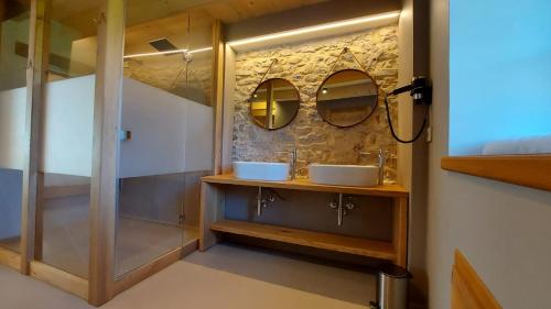 un bagno con due lavandini e due specchi di Corte Varola B&B Zia Marisa a Belluno