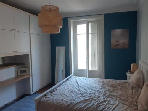 niebieska sypialnia z łóżkiem i oknem w obiekcie Appart de charme 100 m2 centre ville w mieście Rennes