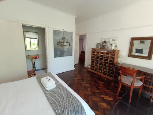 a bedroom with a bed and a table and a chair at John Bauer Pottery Studio in Cape Town