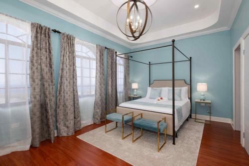 a bedroom with a canopy bed and blue walls at Villa De-Luxe Paradise in Discovery Bay