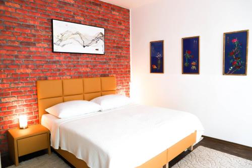 sypialnia z łóżkiem i ceglaną ścianą w obiekcie «Go West» guest rooms w Wiedniu