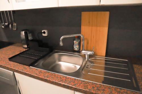 a kitchen sink with a faucet on a counter at «Go West» guest rooms in Vienna