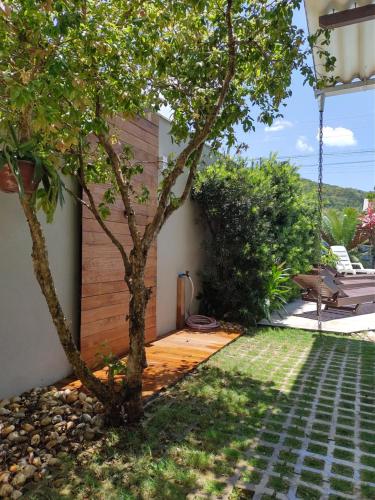 einen Garten mit einem Baum und einer Terrasse in der Unterkunft casa vô Minga in Penha