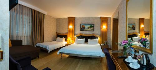ein Hotelzimmer mit 2 Betten und einem Sofa in der Unterkunft Aprilis Hotel - Special Category in Istanbul