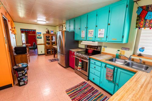 una cocina con armarios azules y electrodomésticos de acero inoxidable en The Wanderlust Hostel, en Gunnison