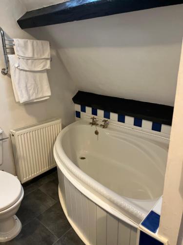 ein Badezimmer mit einer weißen Badewanne und einem WC in der Unterkunft Lulus in St Bees
