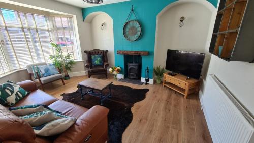 a living room with a couch and a tv at Worthingtons by Spires Accommodation A cosy and comfortable home from home place to stay in Burton-upon-Trent in Burton upon Trent